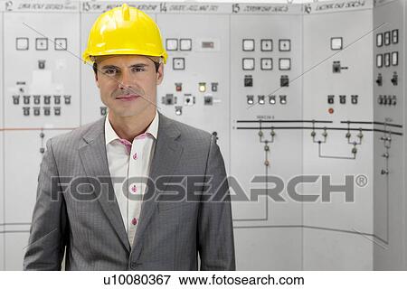 Portrait of confident young male supervisor in control room View Large Photo Image Stock Photo - Portrait of confident young male supervisor in control room. Fotosearch