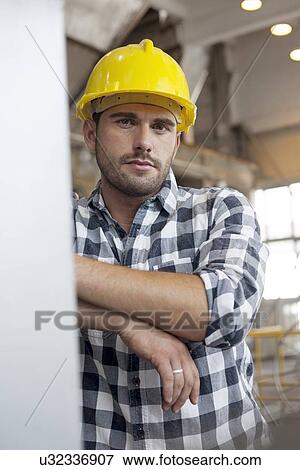 Stock Photo - Portrait of confident young male worker in industry. Fotosearch