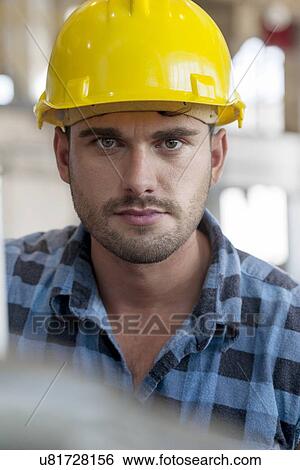 Portrait of confident young male worker in industry View Large Photo Image Stock Photograph - Portrait of confident young male worker in industry. Fotosearch