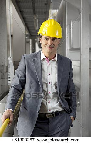 Portrait of confident young manager wearing hard hat in industry View Large Photo Image Stock Photo - Portrait of confident young manager wearing hard hat in industry. Fotosearch