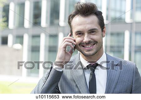 Portrait of happy businessman using cell phone outside office View Large Photo Image Stock Image - Portrait of happy businessman using cell phone outside office. Fotosearch