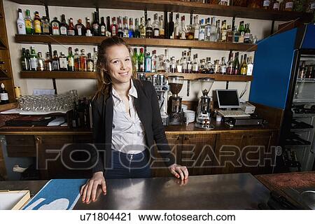 Stock Image - Portrait of happy female cashier at counter in restaurant. Fotosearch