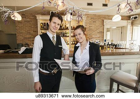Portrait of happy waiter and waitress in restaurant View Large Photo Image Stock Image - Portrait of happy waiter and waitress in restaurant. Fotosearch