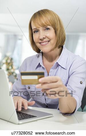 Portrait of happy woman shopping online at home during Christmas View Large Photo Image Stock Image - Portrait of happy woman shopping online at home during Christmas. Fotosearch
