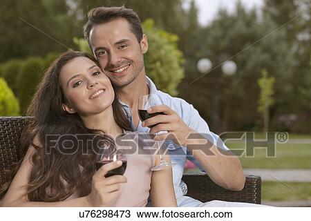 Portrait of happy young couple having red wine together in park View Large Photo Image Stock Image - Portrait of happy young couple having red wine together in park. Fotosearch
