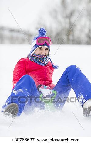 Portrait of happy young woman enjoying sled ride in snow View Large Photo Image Stock Photo - Portrait of happy young woman enjoying sled ride in snow. Fotosearch