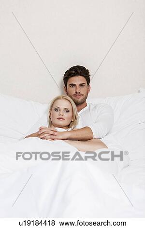 Stock Photo - Portrait of loving young couple resting in bed. Fotosearch