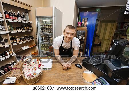 Portrait of salesman leaning at cash counter in supermarket View Large Photo Image Stock Photo - Portrait of salesman leaning at cash counter in supermarket. Fotosearch