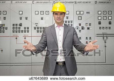 Portrait of serious young male supervisor gesturing in control room View Large Photo Image Stock Photo - Portrait of serious young male supervisor gesturing in control room. Fotosearch