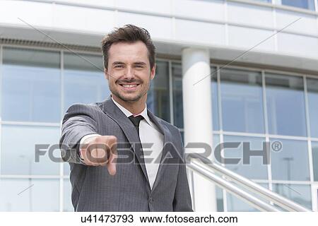 Portrait of smiling businessman pointing at you outside office building View Large Photo Image Stock Image - Portrait of smiling businessman pointing at you outside office building. Fotosearch