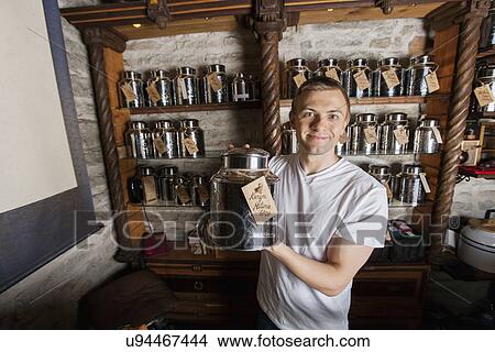 Portrait of smiling male owner displaying tea container in store View Large Photo Image Picture - Portrait of smiling male owner displaying tea container in store. Fotosearch