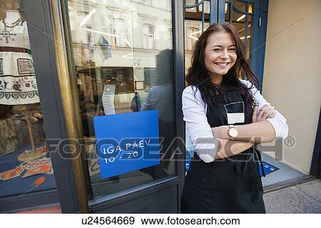 Portrait of smiling saleswoman standing arms crossed outside supermarket View Large Photo Image Stock Photo - Portrait of smiling saleswoman standing arms crossed outside supermarket. Fotosearch