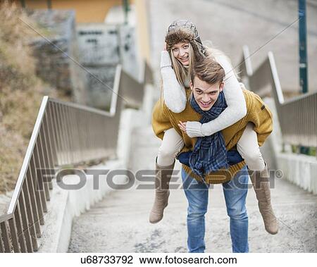 Portrait of smiling woman being piggybacked by man on stairway View Large Photo Image Stock Image - Portrait of smiling woman being piggybacked by man on stairway. Fotosearch