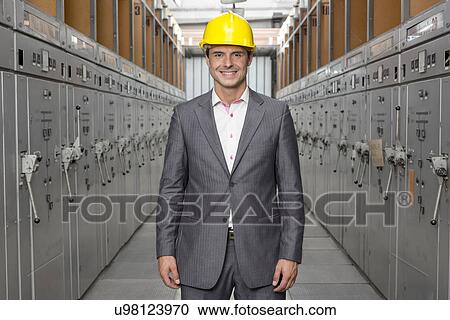 Portrait of smiling young male supervisor standing in control room View Large Photo Image Stock Image - Portrait of smiling young male supervisor standing in control room. Fotosearch