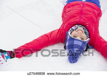 Portrait of smiling young woman lying on snow View Large Photo Image Stock Photo - Portrait of smiling young woman lying on snow. Fotosearch