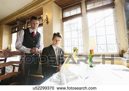 Portrait of waiter and businessman at restaurant table View Large Photo Image Stock Image - Portrait of waiter and businessman at restaurant table. Fotosearch