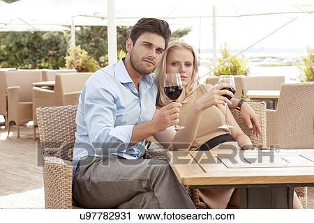 Portrait of young couple having red wine at outdoor restaurant View Large Photo Image Stock Image - Portrait of young couple having red wine at outdoor restaurant. Fotosearch