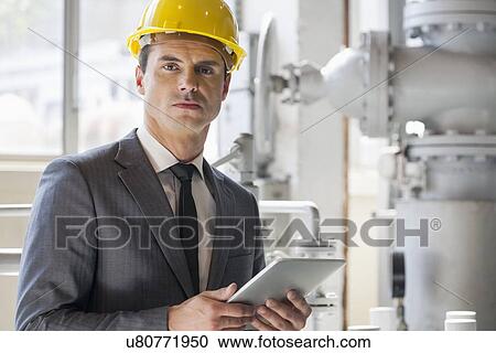 Portrait of young male architect holding tablet computer in industry View Large Photo Image Stock Image - Portrait of young male architect holding tablet computer in industry. Fotosearch