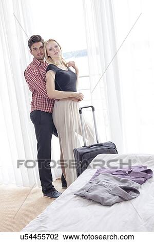 Portrait of young man embracing woman from behind in hotel room View Large Photo Image Stock Image - Portrait of young man embracing woman from behind in hotel room. Fotosearch