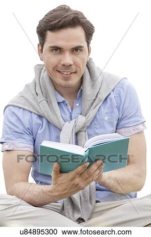 Portrait of young man reading book against sky View Large Photo Image Stock Image - Portrait of young man reading book against sky. Fotosearch