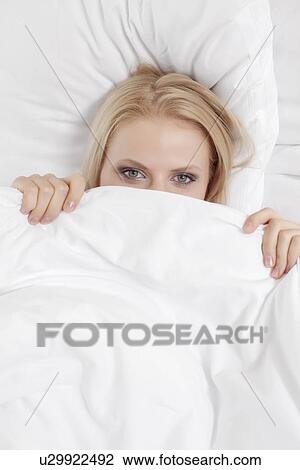 Portrait of young woman covering face with bed sheet View Large Photo Image Stock Image - Portrait of young woman covering face with bed sheet. Fotosearch
