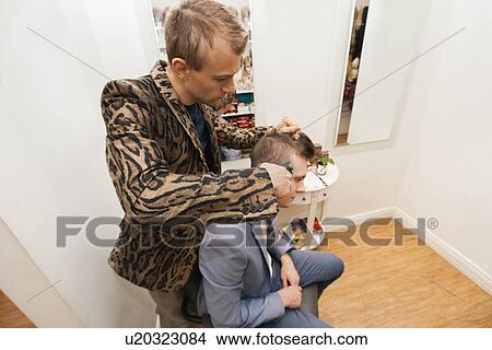 Picture - Professional barber shaving male customer's hair in shop. Fotosearch