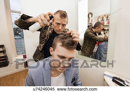 Professional barber using hairspray on male customer in shop View Large Photo Image Stock Photography - Professional barber using hairspray on male customer in shop. Fotosearch