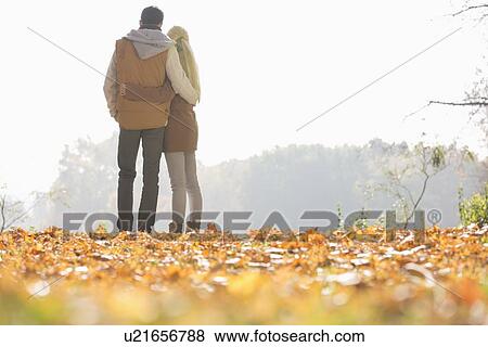 Rear view of couple looking at view in park during autumn View Large Photo Image Stock Photo - Rear view of couple looking at view in park during autumn. Fotosearch
