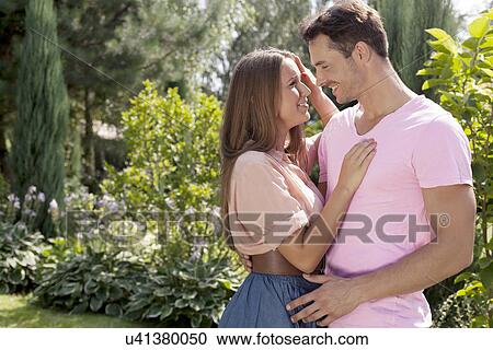 Stock Image - Romantic couple looking at each other in park. Fotosearch