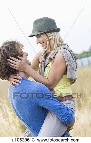 Romantic man carrying woman in field View Large Photo Image Stock Image - Romantic man carrying woman in field. Fotosearch