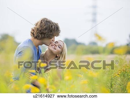 Romantic man kissing woman in field View Large Photo Image Stock Photo - Romantic man kissing woman in field. Fotosearch