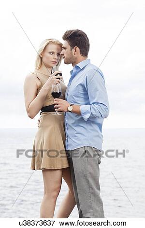 Romantic young couple having red wine against sea View Large Photo Image Stock Photo - Romantic young couple having red wine against sea. Fotosearch