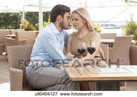 Stock Photo - Romantic young couple spending quality time at outdoor restaurant. Fotosearch