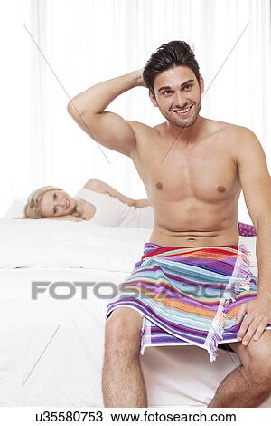 Shirtless young man smiling with woman in background at hotel room View Large Photo Image Stock Image - Shirtless young man smiling with woman in background at hotel room. Fotosearch