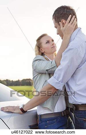 Side view of romantic young couple by car at countryside View Large Photo Image Stock Image - Side view of romantic young couple by car at countryside. Fotosearch