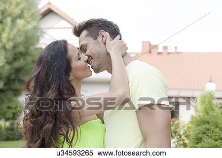 Side view of romantic young couple kissing outdoors View Large Photo Image Stock Photography - Side view of romantic young couple kissing outdoors. Fotosearch