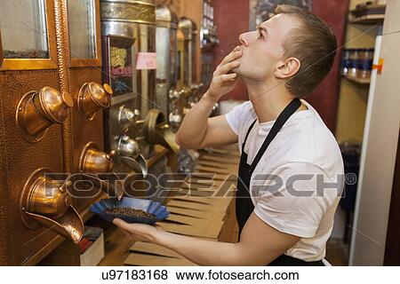 Side view of salesperson dispensing coffee beans into bowl at store View Large Photo Image Stock Photo - Side view of salesperson dispensing coffee beans into bowl at store. Fotosearch