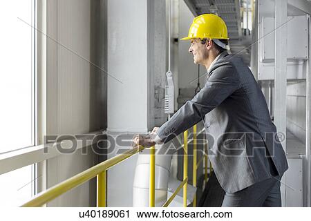 Side view of smiling male architect leaning on railing in industry View Large Photo Image Stock Image - Side view of smiling male architect leaning on railing in industry. Fotosearch