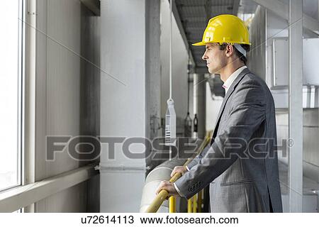 Side view of thoughtful male architect standing by railing in industry View Large Photo Image Stock Image - Side view of thoughtful male architect standing by railing in industry. Fotosearch