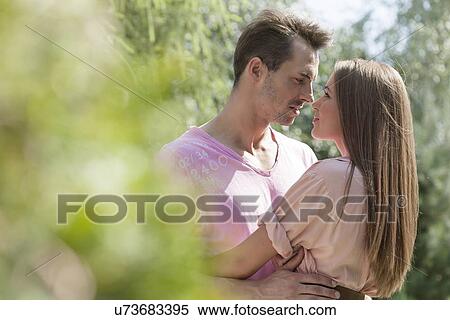 Side view of young romantic couple in park View Large Photo Image Stock Photography - Side view of young romantic couple in park. Fotosearch