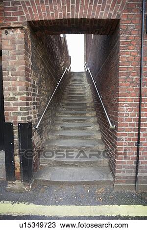 Stock Image - Steps through brick wall at London, England, UK. Fotosearch