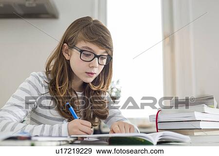 Teenage girl doing homework at table View Large Photo Image Stock Photo - Teenage girl doing homework at table. Fotosearch