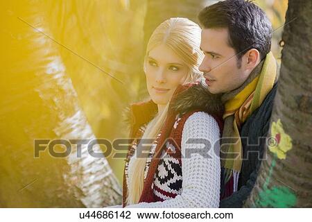 Thoughtful loving couple looking away in park View Large Photo Image Stock Image - Thoughtful loving couple looking away in park. Fotosearch