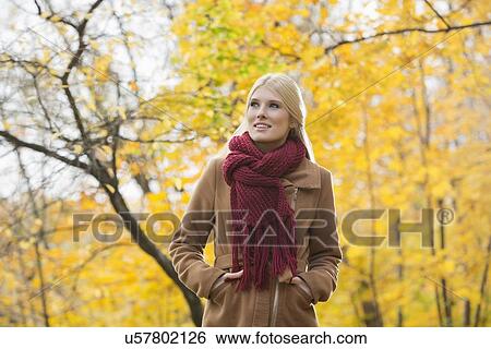 Thoughtful woman in jacket looking away at park during autumn View Large Photo Image Stock Photograph - Thoughtful woman in jacket looking away at park during autumn. Fotosearch