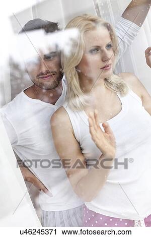 Thoughtful young couple looking through hotel window View Large Photo Image Stock Image - Thoughtful young couple looking through hotel window. Fotosearch