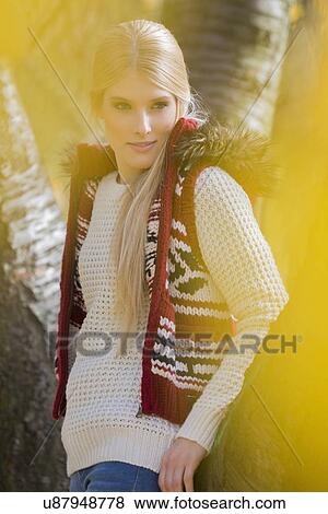 Thoughtful young woman in warm clothing standing in park View Large Photo Image Stock Photo - Thoughtful young woman in warm clothing standing in park. Fotosearch