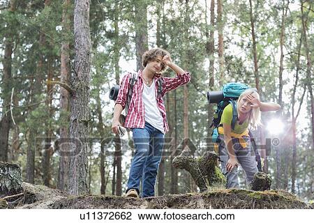 Stock Image - Tired hiking couple in forest. Fotosearch