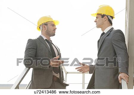 Two young male architect discussing on stairway View Large Photo Image Stock Photograph - Two young male architect discussing on stairway. Fotosearch