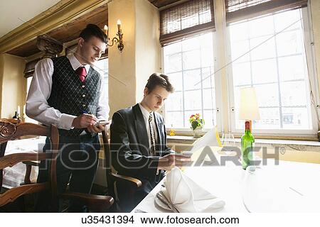 Waiter taking businessman's order at restaurant View Large Photo Image Picture - Waiter taking businessman's order at restaurant. Fotosearch
