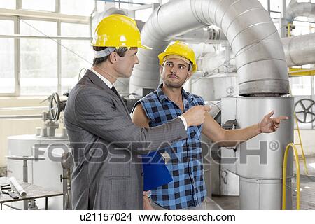 Picture - Worker with manager inspecting industrial area. Fotosearch